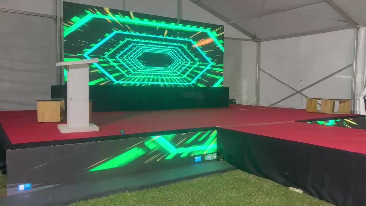 Corporate stage inside a tent with a lectern and full-width LED wall