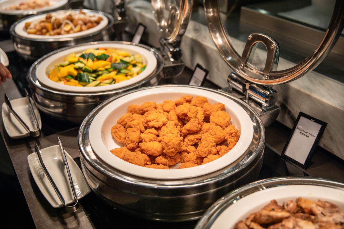 Chafing dishes of hot food laid out along a buffet counter