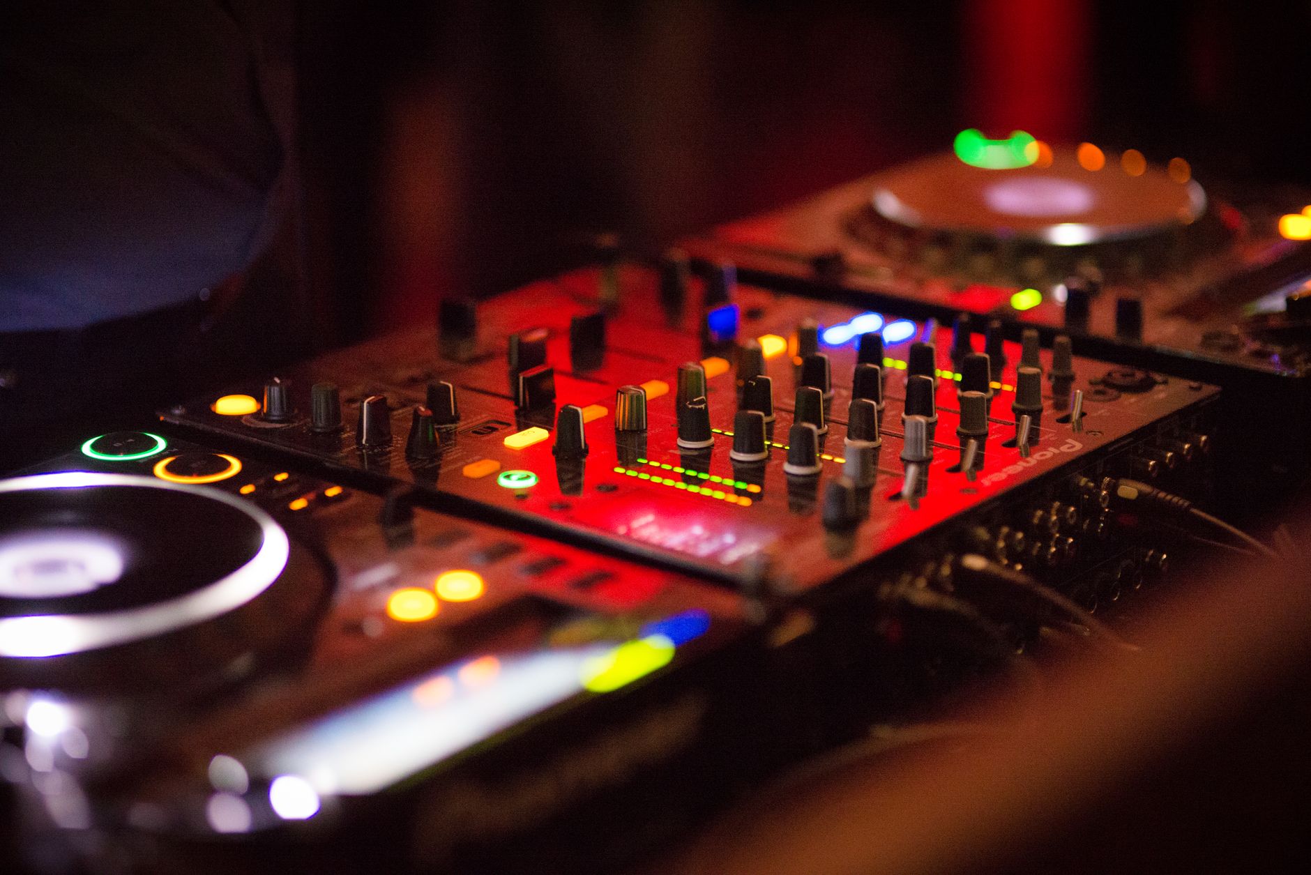 DJ mixer and controller lit red at a live set