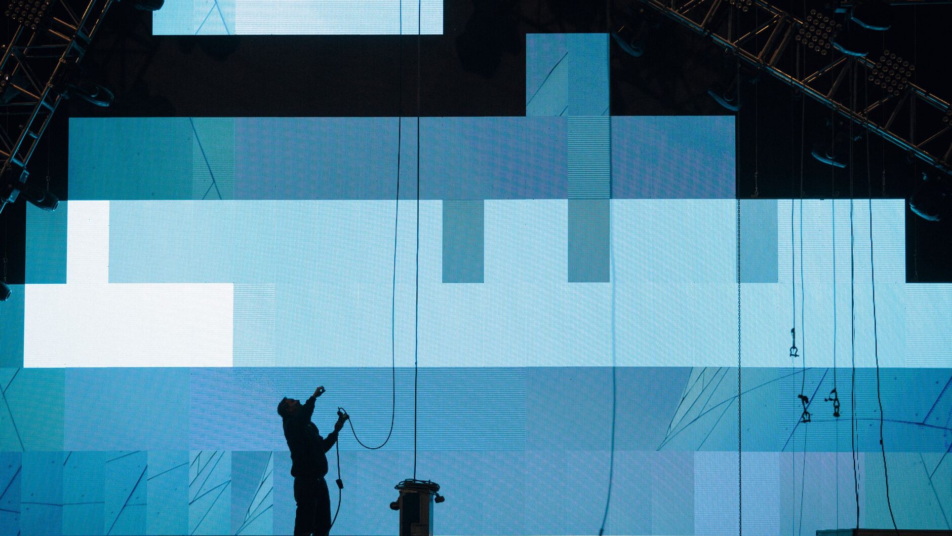 Crew member rigging panels on a large LED video wall