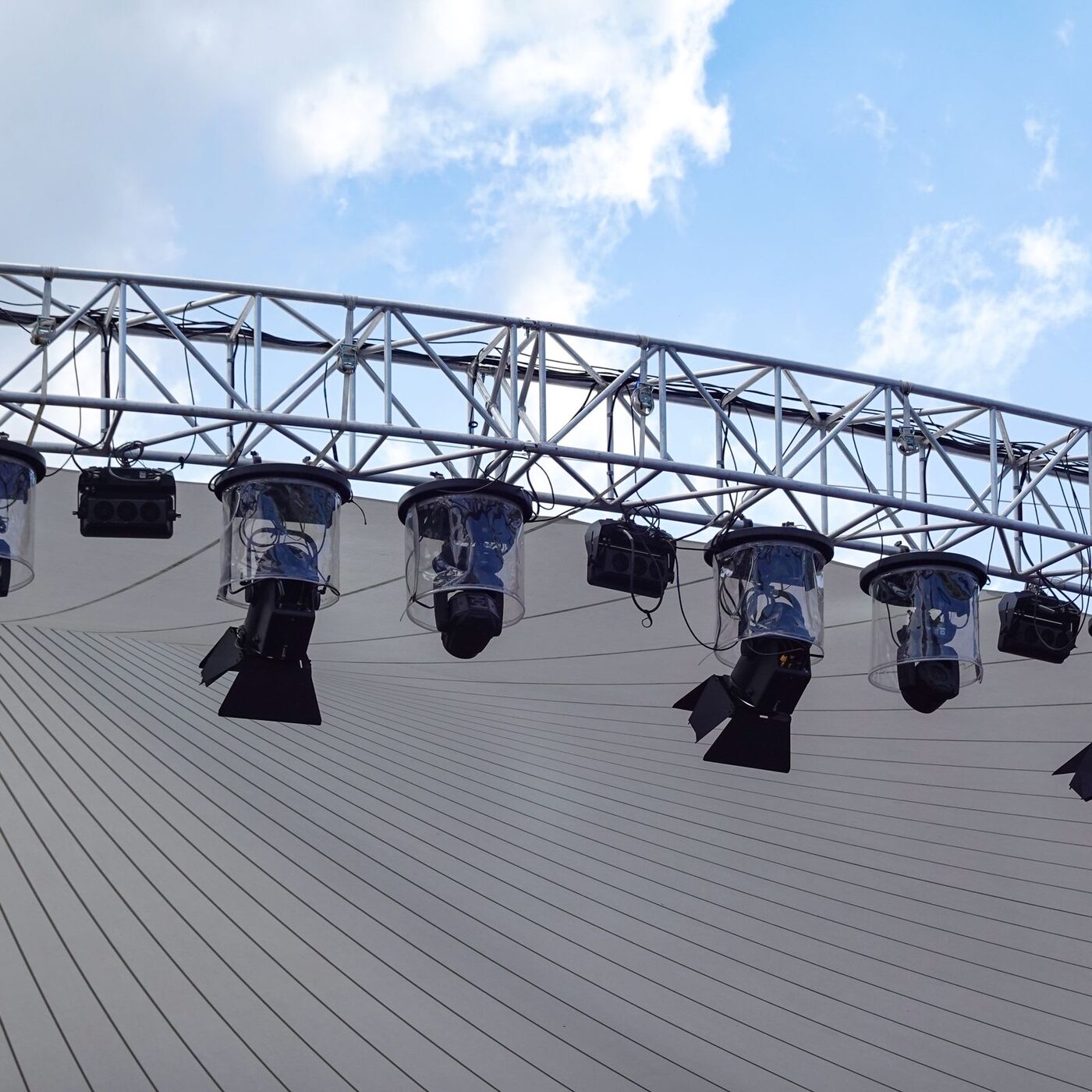 Truss span over an open stage with fixtures clamped along it